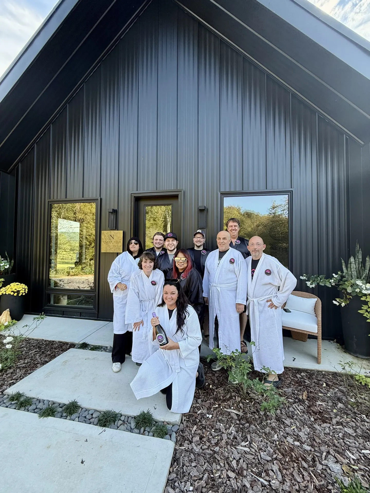 A group in spa robes outside a cabin.